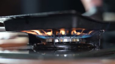 Yakıt düğmesi yanıyor, alev gibi görünüyor. Gaz mavisi ocak alevi. Restoran mutfağında propan bütan gazı ve ev ısıtması. Petrol ve gaz endüstrisi, kriz, kaynaklar, ekonomi konsepti. Yavaş