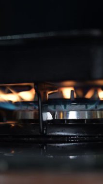 Yakıt düğmesi yanıyor, alev gibi görünüyor. Gaz mavisi ocak alevi. Restoran mutfağında propan bütan gazı ve ev ısıtması. Petrol ve gaz endüstrisi, kriz, kaynaklar, ekonomi konsepti. Yavaş