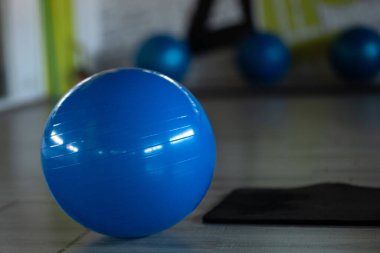 Egzersiz topunun spor salonunun ortasına yerleştirilmiş mavi egzersiz topu yoga içindir. Çeşitli kas gevşeme terapileri.
