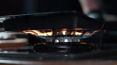 Yakıt düğmesi yanıyor, alev gibi görünüyor. Gaz mavisi ocak alevi. Restoran mutfağında propan bütan gazı ve ev ısıtması. Petrol ve gaz endüstrisi, kriz, kaynaklar, ekonomi konsepti. Yavaş