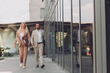 Uzun bir çalışmadan sonra modern iş çifti, evlerinin rahatlığı için birlikte yürüyorlar, profesyonel başarı ve kişisel memnuniyetin mükemmel bir karışımını oluşturuyorlar..