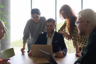 Şirketin müdürüyle birlikte çeşitli iş adamları modern bir ofiste iş başarılarını gözden geçirip strateji ve ilerlemeyi tartışıyorlar..