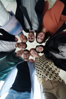 Düşük açılı bir perspektiften, güven ve takım çalışması yayarak güçlü ve birleşik bir şekilde bir arada duran çeşitli iş adamları grubu.. 