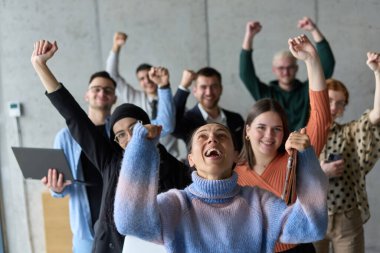 Çeşitli iş adamlarından oluşan bir ekip modern bir ofiste başarılarını coşkuyla kutluyor, amaçlarına ulaştıktan sonra zafer ve birlik içinde olduklarını ifade ediyorlar.. 