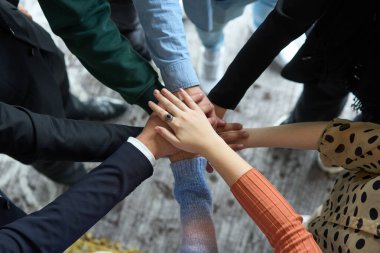 İş adamlarının bir daire içinde el ele tutuşması, birlik, işbirliği ve iş yerinde ortak başarının simgesi..