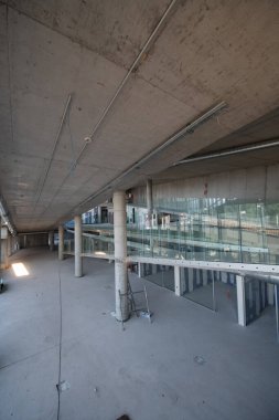 Yapım aşamasındaki modern bir iş binasının büyüleyici bir görüntüsü, çiğ endüstriyel iç mekânını, gün batımının sıcak, altın sarısı renkleri ile yıkanmış çelik kirişleri ve beton duvarlarıyla sergiliyor.. 