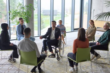 Şirket işletme ekibi bir yönetici veya koçla toplantı yapıyor. Bir grup mutlu, çok ırklı insan bir çemberin içinde oturuyor. .