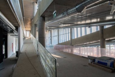 Yapım aşamasındaki modern bir iş binasının büyüleyici bir görüntüsü, çiğ endüstriyel iç mekânını, gün batımının sıcak, altın sarısı renkleri ile yıkanmış çelik kirişleri ve beton duvarlarıyla sergiliyor.. 
