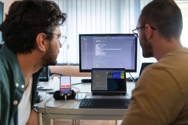 Derin işbirliğine dalmış programcılar, karmaşık sorunları çözmek ve sorunsuz işlevselliğe sahip yenilikçi mobil uygulamalar geliştirmek için özenle birlikte çalışıyorlar