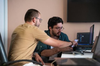 Programcılardan oluşan dinamik bir ekip bilgisayarlarında canlı bir tartışma ve problem çözme, ofiste işbirliği ve yaratıcılığı teşvik ediyor.