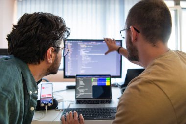 Derin işbirliğine dalmış programcılar, karmaşık sorunları çözmek ve sorunsuz işlevselliğe sahip yenilikçi mobil uygulamalar geliştirmek için özenle birlikte çalışıyorlar