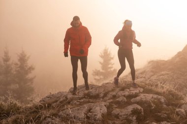 Dağ yolunda koşan bir çiftin izini sürüyorum. Bir çift sabahın erken saatlerinde kros koşusu yapıyor..
