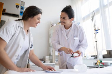 Bir hastane laboratuvarında iki hemşire hastalar ve hastane kullanımı için ilaçları dikkatlice inceliyor ve hazırlıyorlar.