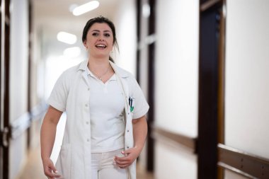 Doktorlar ve hemşireler de dahil olmak üzere sağlık personeli, yoğun bir hastane koridorunda acil müdahale ve kritik bir durumda ekip çalışmalarını sergileyerek acil müdahale ediyor.