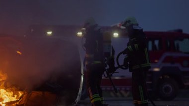 İtfaiyeciler yangını kontrol etmek için alevlerle savaşır, yayılmak için değil. İtfaiyeci endüstriyel ve kamu güvenliği kavramı. Trafik ya da araba kazası kurtarma ve eyleme yardım. Yüksek kalite fotoğraf