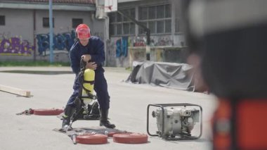 İtfaiyecilerden oluşan özel bir ekip bir itfaiye aracından hortumları alıyor ve tehlikeli bir tehlikeyle mücadele etmedeki cesaret ve profesyonel uzmanlıklarını sergileyerek, yanan bir yangını söndürmek için tehlikeli bir göreve çıkıyorlar.