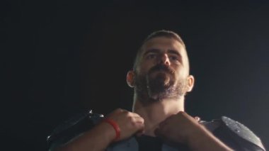 Bir Amerikan futbolcusunun yakın plan portresi yoğun bir antrenmandan sonra terliyor, atletizm ve kararlılık sergiliyor. Sporla ilgili içerik ve motivasyonel görseller için ideal