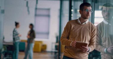 Üst düzey iş adamı, bilişim uzmanı, tüccar ve kripto yatırımcısı modern bir çalışma alanında dijital tablet kullanıyor. Açık ofis ortamında çalışan teknoloji meraklısı bir profesyonel..