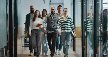 Modern bir açık mekan ofisinin iş ekibi birlikte yürüyor. Çeşitli iş adamları tartışırken gülümsüyor. Başarılı karma ırk meslektaşları yeni bir projede işbirliği yapıyorlar