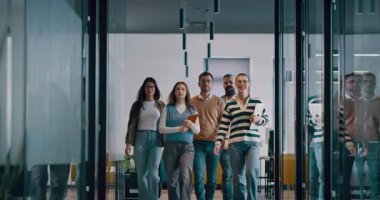 Modern bir açık mekan ofisinin iş ekibi birlikte yürüyor. Çeşitli iş adamları tartışırken gülümsüyor. Başarılı karma ırk meslektaşları yeni bir projede işbirliği yapıyorlar