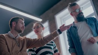 Moden ofis alanı, iş dünyasından profesyonellerden oluşan bir ekip canlı tartışmalara girişiyor ve stratejik fikirleri paylaşıyor, modern kurumsal açık alanların merkezinde işbirliği ve yenilik sergiliyor.