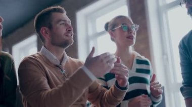 Moden ofis alanı, iş dünyasından profesyonellerden oluşan bir ekip canlı tartışmalara girişiyor ve stratejik fikirleri paylaşıyor, modern kurumsal açık alanların merkezinde işbirliği ve yenilik sergiliyor.