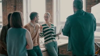 Moden ofis alanı, iş dünyasından profesyonellerden oluşan bir ekip canlı tartışmalara girişiyor ve stratejik fikirleri paylaşıyor, modern kurumsal açık alanların merkezinde işbirliği ve yenilik sergiliyor.