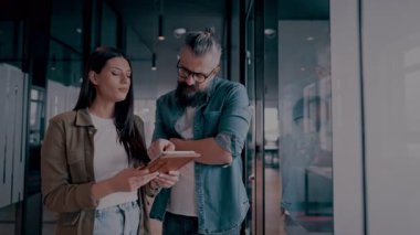 Yaratıcı milenyumlar, sıradan iş adamları, küçük işletme sahipleri, sosyal medya stratejisi ve marka geliştirme üzerinde çalışan modern, açık bir ofis ortamında dijital tabletle