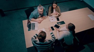 Moden ofis alanı, iş dünyasından profesyonellerden oluşan bir ekip canlı tartışmalara girişiyor ve stratejik fikirleri paylaşıyor, modern kurumsal açık alanların merkezinde işbirliği ve yenilik sergiliyor.