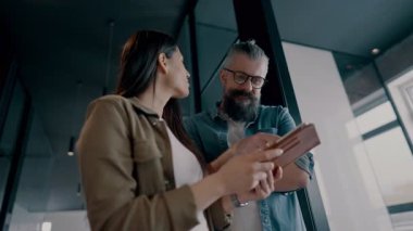 Yaratıcı milenyumlar, sıradan iş adamları, küçük işletme sahipleri, sosyal medya stratejisi ve marka geliştirme üzerinde çalışan modern, açık bir ofis ortamında dijital tabletle