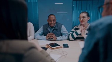 Moden ofis alanı, iş dünyasından profesyonellerden oluşan bir ekip canlı tartışmalara girişiyor ve stratejik fikirleri paylaşıyor, modern kurumsal açık alanların merkezinde işbirliği ve yenilik sergiliyor.