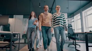 Modern bir açık mekan ofisinin iş ekibi birlikte yürüyor. Çeşitli iş adamları tartışırken gülümsüyor. Başarılı karma ırk meslektaşları yeni bir projede işbirliği yapıyorlar