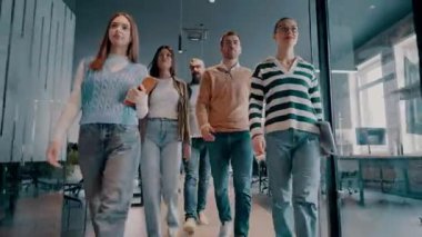 Modern bir açık mekan ofisinin iş ekibi birlikte yürüyor. Çeşitli iş adamları tartışırken gülümsüyor. Başarılı karma ırk meslektaşları yeni bir projede işbirliği yapıyorlar