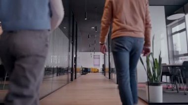 Modern bir açık mekan ofisinin iş ekibi birlikte yürüyor. Çeşitli iş adamları tartışırken gülümsüyor. Başarılı karma ırk meslektaşları yeni bir projede işbirliği yapıyorlar