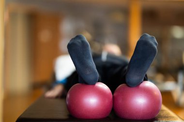 Hasta bacakları rehabilitasyon topları üzerinde dinlenirken, iyileşme sürecinde ve iyileşme sürecinde esnekliği artırırken yakın plan bir çekim.