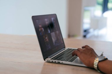 Modern iç mimarisi olan bir evin ahşap bir masasında modern kulaklıklı bir dizüstü bilgisayarın fotoğrafı.