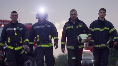 Cesur İtfaiyeciler Ekibi Kameraya Yürüyor. Arka plan Sağlık Ekibi ve İtfaiyeci Kurtarma Ekibi Araba Kazası, Sigorta ve Hayat Kurtarma konseptinde İtfaiyeye Karşı. Yüksek kalite fotoğraf