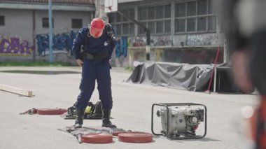 İtfaiyecilerden oluşan özel bir ekip bir itfaiye aracından hortumları alıyor ve tehlikeli bir tehlikeyle mücadele etmedeki cesaret ve profesyonel uzmanlıklarını sergileyerek, yanan bir yangını söndürmek için tehlikeli bir göreve çıkıyorlar.