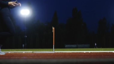 Dişi sporcu bir engele doğru koşuyor, engelli koşuyor, yüksek hızda bariyerin üzerinden atlıyor bir yarışta koşarken. Hız Rampası Efektli Süper Yavaş Sinema Görüntüsü.