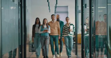 Modern bir açık mekan ofisinin iş ekibi birlikte yürüyor. Çeşitli iş adamları tartışırken gülümsüyor. Başarılı karma ırk meslektaşları yeni bir projede işbirliği yapıyorlar