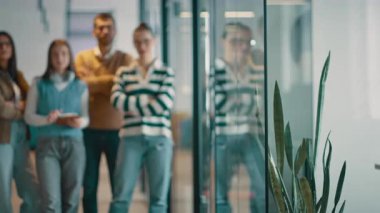 Modern bir ofiste, açık bir alanda işbirliği yapan çeşitli, etnik çeşitlilikte girişimci ve liderlerden oluşan bir iş ekibi. Takım çalışmaları, motivasyonları ve ortaklıkları şirketlerin büyümesini ve başarısını besliyor.