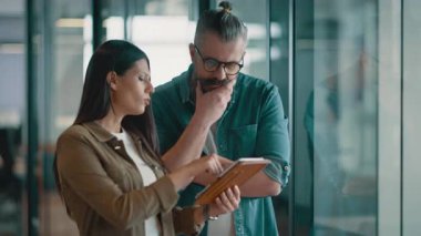 Yaratıcı milenyumlar, sıradan iş adamları, küçük işletme sahipleri, sosyal medya stratejisi ve marka geliştirme üzerinde çalışan modern, açık bir ofis ortamında dijital tabletle