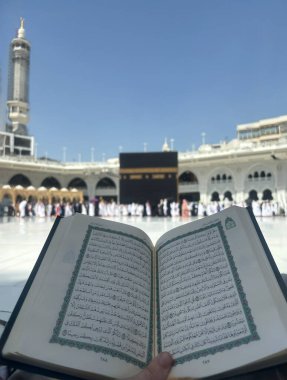 Mekke, Suudi Arabistan, 02 Mayıs 2024, Mescidi Haram, Mekke, Suudi Arabistan 'da Kabe önünde Kur' an okunuyor. Tapanlar kutsal mekânın etrafında Tawaf yapıyorlar. Açık mavi bir gökyüzünün altında.