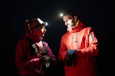 Eğitimden sonra nefes almaktan sıkılan koşucular, teknoloji sporu saatlerine bakmaktan, kalp atış hızı verilerini ve navigasyonlarını kontrol etmekten bıktılar. İki sporcu bir dağda birlikte koşuyor..