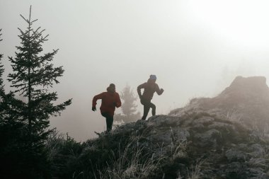 Dağ yolunda koşan bir çiftin izini sürüyorum. Bir çift sabahın erken saatlerinde kros koşusu yapıyor..
