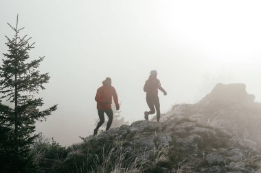 Dağ yolunda koşan bir çiftin izini sürüyorum. Bir çift sabahın erken saatlerinde kros koşusu yapıyor..