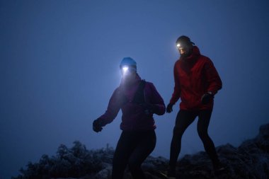 İki sporcu gece boyunca engebeli dağ patikalarında koşar, far ve kış giysileri giyerek, soğuk, sisli arazide kararlılık ve dayanıklılıkla yol alırlar..