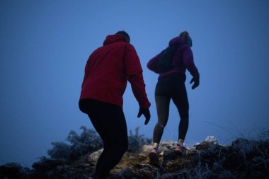 İki sporcu gece boyunca engebeli dağ patikalarında koşar, far ve kış giysileri giyerek, soğuk, sisli arazide kararlılık ve dayanıklılıkla yol alırlar..