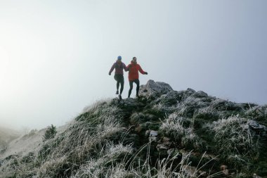 Dağ yolunda koşan bir çiftin izini sürüyorum. Bir çift sabahın erken saatlerinde kros koşusu yapıyor..