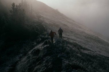 Dağ yolunda koşan bir çiftin izini sürüyorum. Bir çift sabahın erken saatlerinde kros koşusu yapıyor..